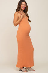 pregnant woman wearing an orange ribbed maternity maxi dress and tan block heel sandals