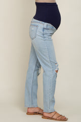 woman wearing light blue distressed maternity jeans with a navy belly band and visible baby bump