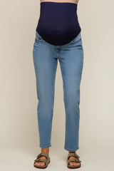 maternity wear blue skinny jeans with a comfortable over-the-bump panel, worn by a model showing a baby bump