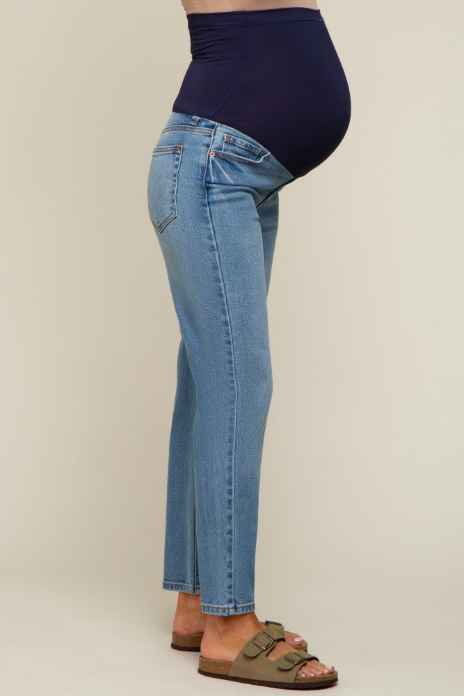 woman wearing blue maternity jeans with a navy belly panel, showing her baby bump and styled with sandals