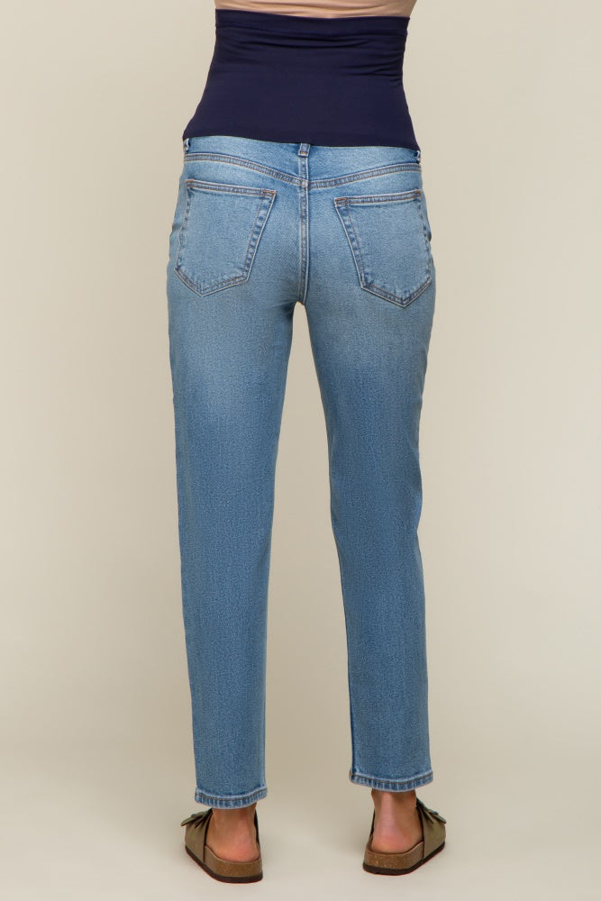 woman wearing light blue maternity jeans seen from the back, featuring a tapered leg and a stretch waistband