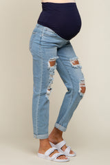 woman wearing maternity distressed light blue jeans with a dark blue waistband and a visible baby bump