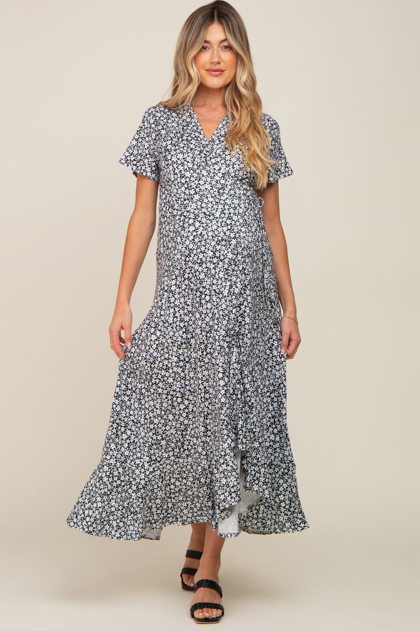 woman wearing a black and white floral print short sleeve maternity wrap maxi dress