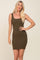 Woman with blonde hair wearing an olive green ribbed bodycon mini dress with a scoop neckline