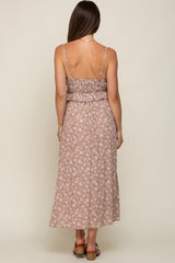 Back view of a woman wearing a mauve floral print maxi dress with spaghetti straps and ruffle detail