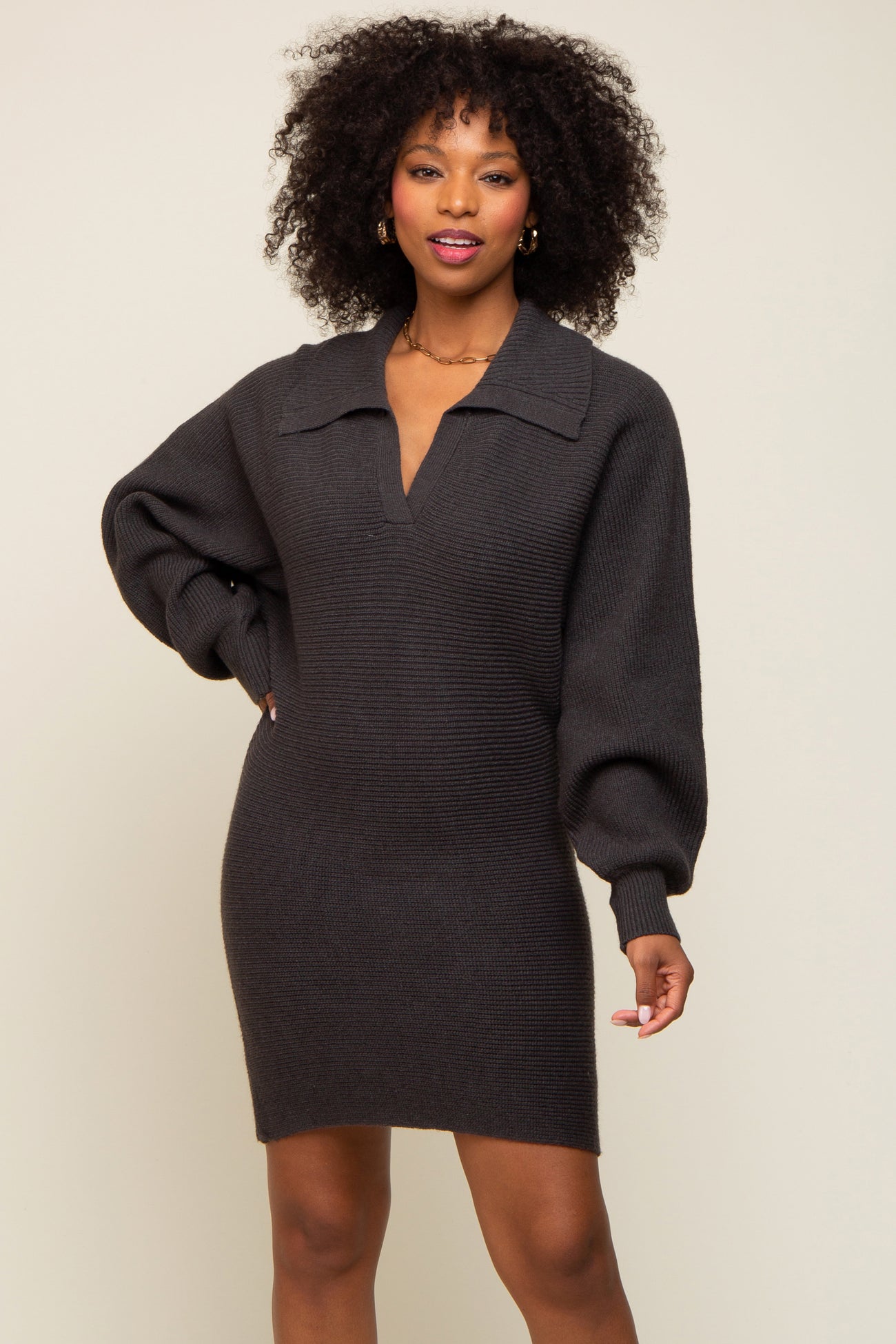 Woman wearing a charcoal grey ribbed knit sweater dress with a collar and balloon sleeves