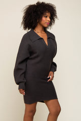 Woman with curly hair wearing a charcoal grey ribbed knit sweater dress with a collar and v-neckline
