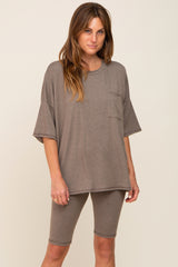 woman wearing a brown oversized t-shirt with a front pocket and matching bike shorts