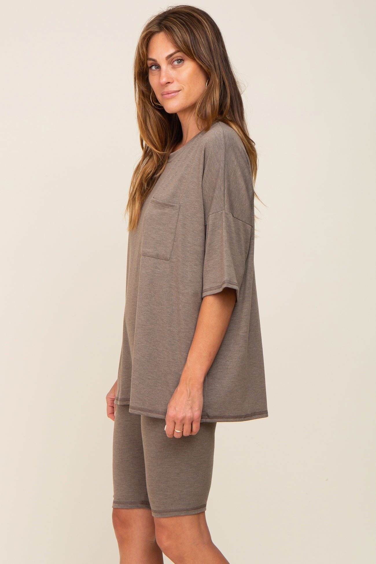 woman wearing a taupe oversized t-shirt with pocket and matching bike shorts