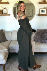 woman wearing an olive green off-the-shoulder maternity dress with billowy sleeves, styled with brown ankle boots and a baby bump visible