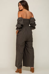 woman wearing a grey off-shoulder maternity jumpsuit with ruffled sleeves and wide legs