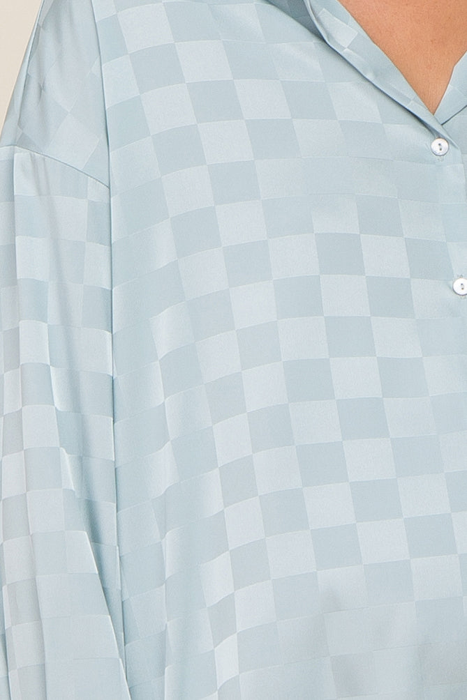 Close-up of a light blue satin button-down shirt with a tonal checkered pattern