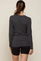 woman wearing a dark gray long sleeve maternity top viewed from the back with black shorts