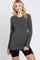 woman wearing a dark gray long sleeve top with a round neckline and slim fit, paired with black bike shorts