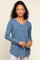 woman wearing a blue long sleeve v-neck top with a relaxed fit and side slits