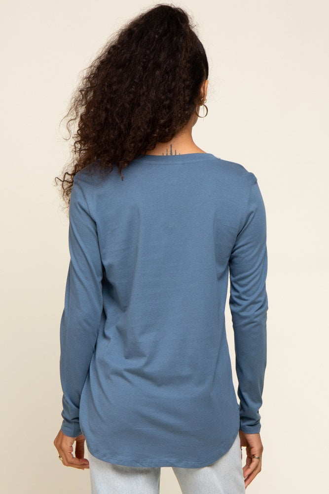 woman wearing a blue long sleeve top with a rounded hem and back view