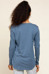 woman wearing a blue long sleeve top with a rounded hem and back view