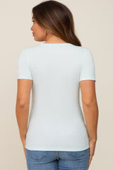 woman wearing a light mint green short sleeve maternity top, view of the back with fitted style details and blue jeans