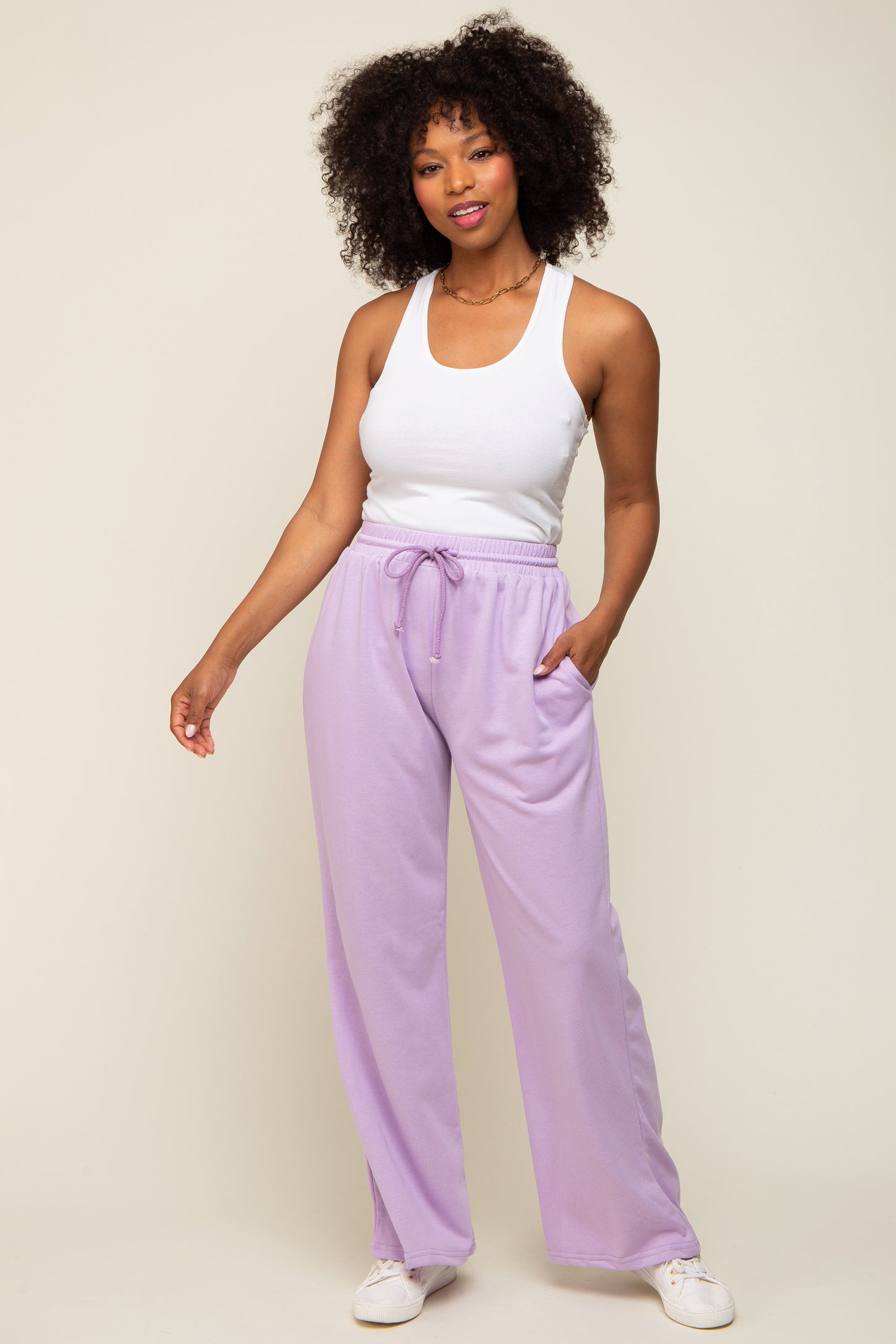 woman wearing white tank top and lavender wide leg sweatpants with drawstring waist