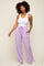 woman wearing white tank top and lavender wide leg sweatpants with drawstring waist