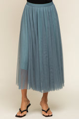 woman wearing a sheer teal tulle midi skirt with an elastic waistband and flowy layered design