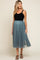 woman wearing a black tank top and a teal tulle maternity skirt, with a flowing design and a relaxed fit