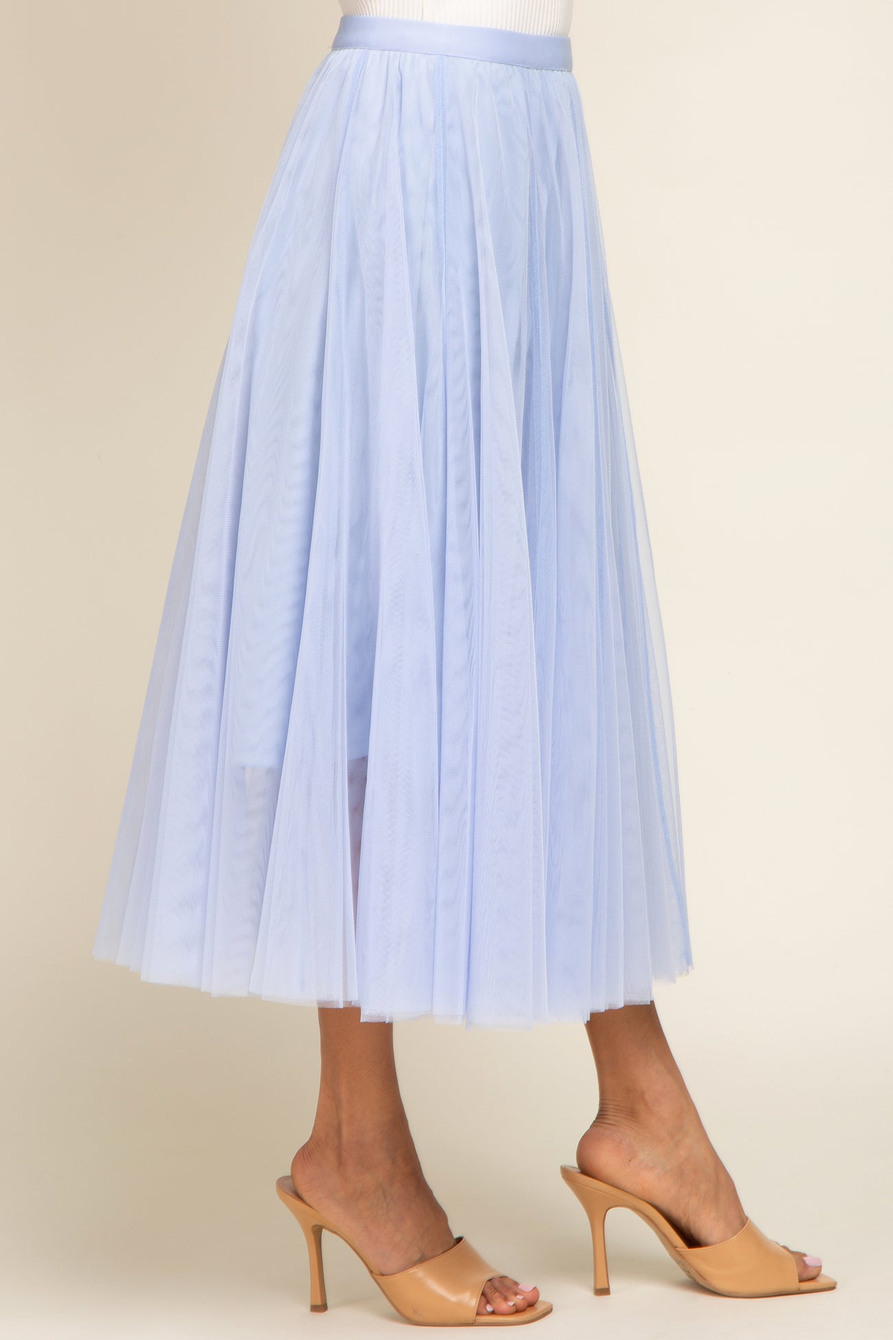 woman wearing a light blue tulle midi skirt and nude heeled sandals