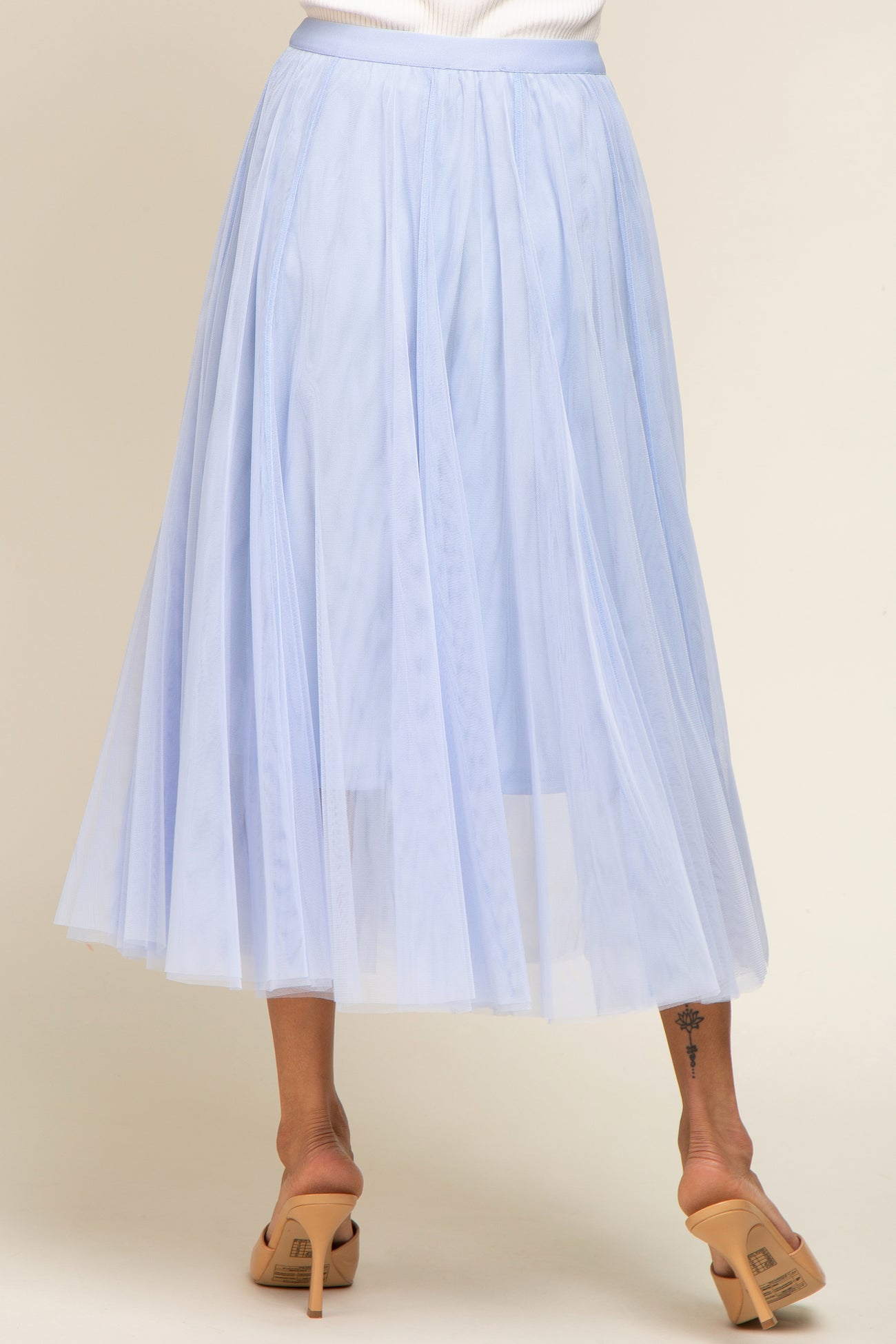 light blue tulle midi skirt with an elastic waistband, styled with a flowy and layered design