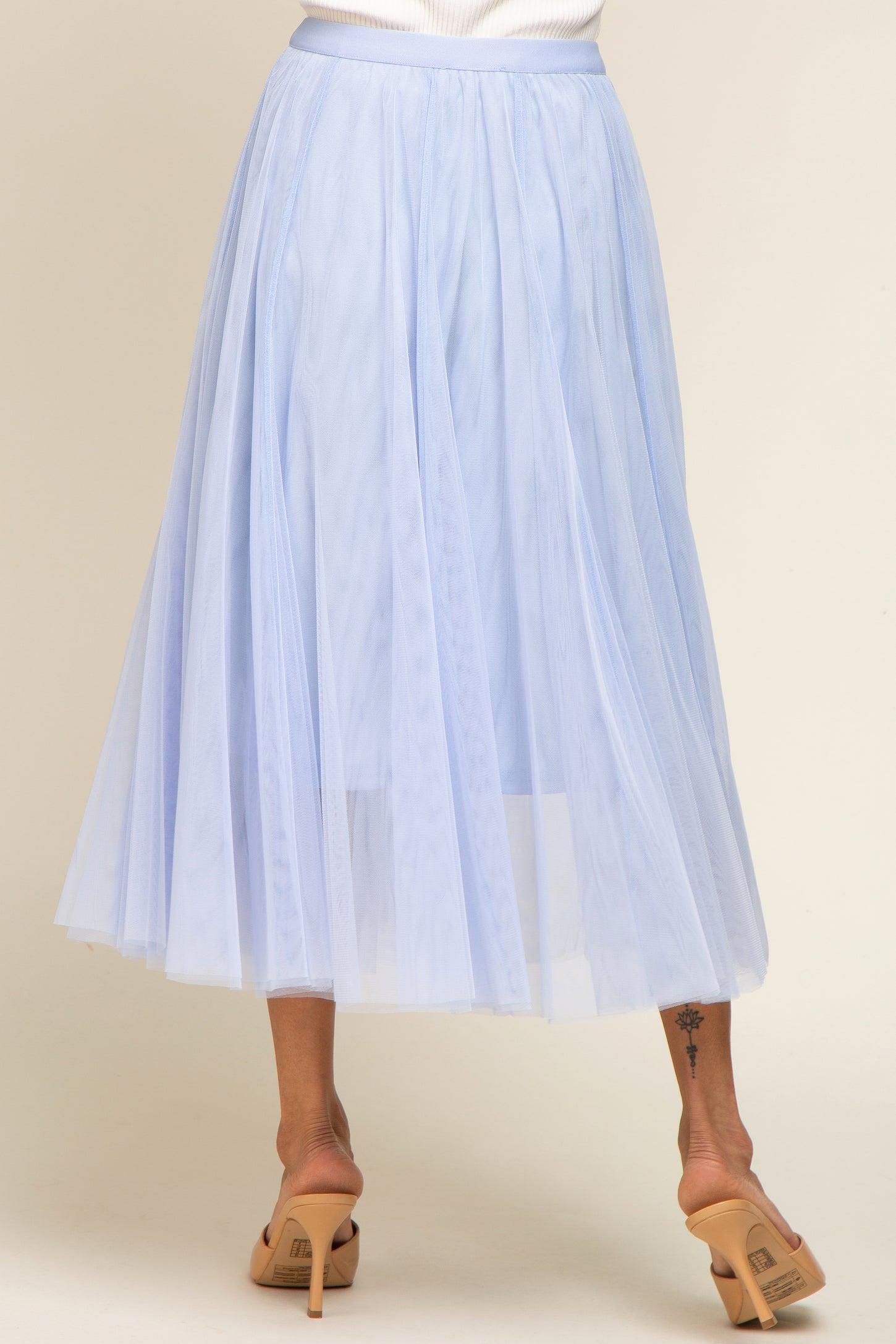 light blue tulle midi skirt with an elastic waistband, styled with a flowy and layered design