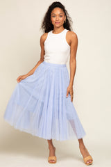 woman wearing a white ribbed tank top and a light blue tulle maxi skirt