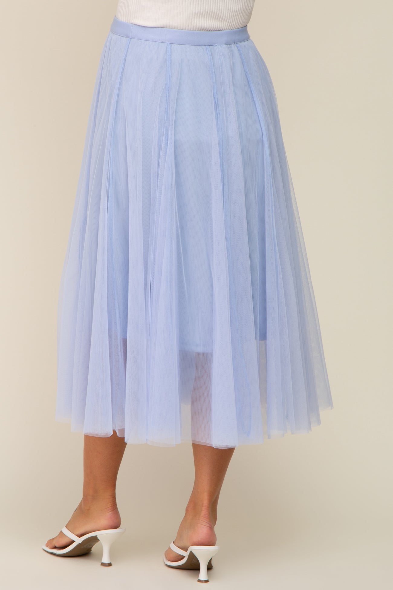 woman wearing a light blue maternity tulle midi skirt, showcasing a flowy design and layered texture from the back