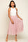woman wearing a white ribbed sleeveless top and a light pink pleated tulle midi skirt