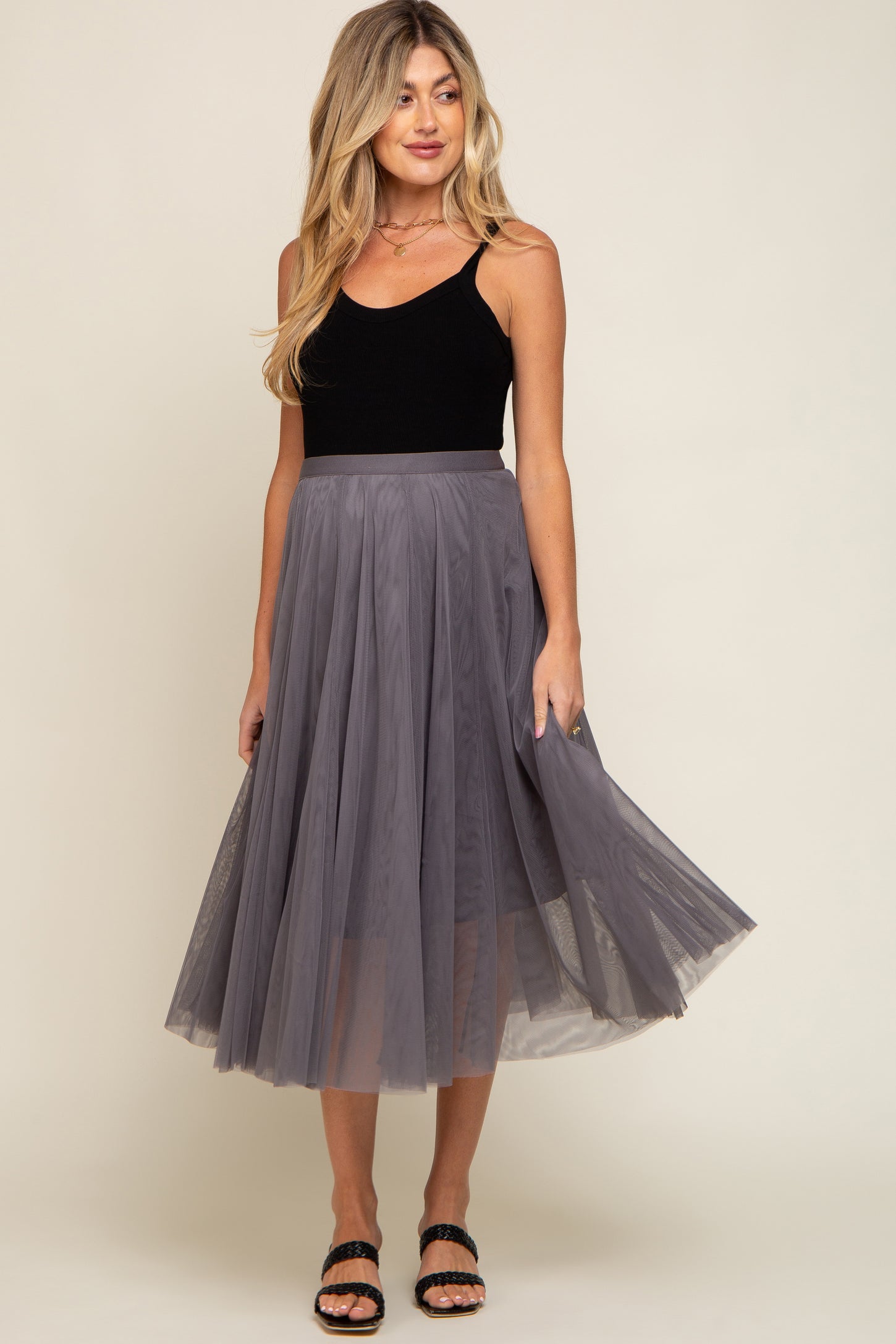 woman wearing a black maternity tank top and a flowy gray tulle midi skirt