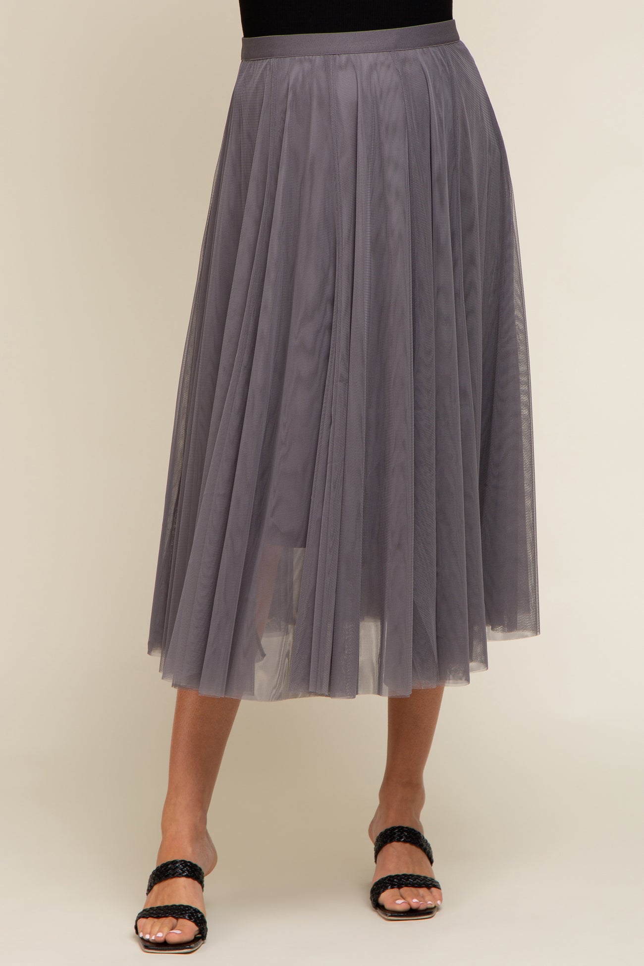 woman wearing a lavender tulle maternity skirt with a pleated design and paired with black sandals