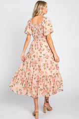 woman wearing a pink floral maxi dress with puff sleeves and a tiered skirt, shown from the back