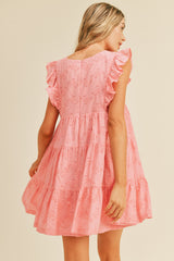 woman wearing a pink eyelet tiered dress with ruffle sleeves, shown from the back