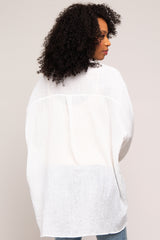 woman wearing a loose-fitting white oversized button-up shirt with a relaxed silhouette and side slits