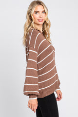woman wearing a brown and white striped oversized knit sweater with balloon sleeves