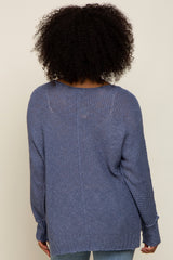 woman wearing a cozy blue oversized knit sweater, view from the back showing relaxed fit and textured fabric