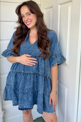woman wearing a denim maternity dress with ruffle details and a visible baby bump