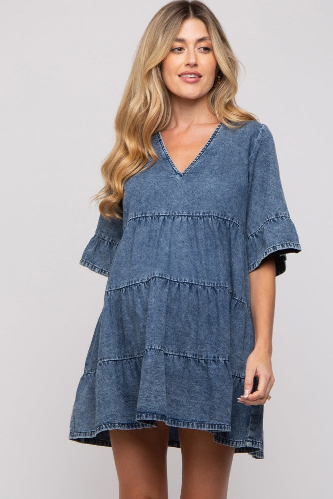 woman wearing a denim maternity dress with a tiered design and short sleeves, showcasing her baby bump