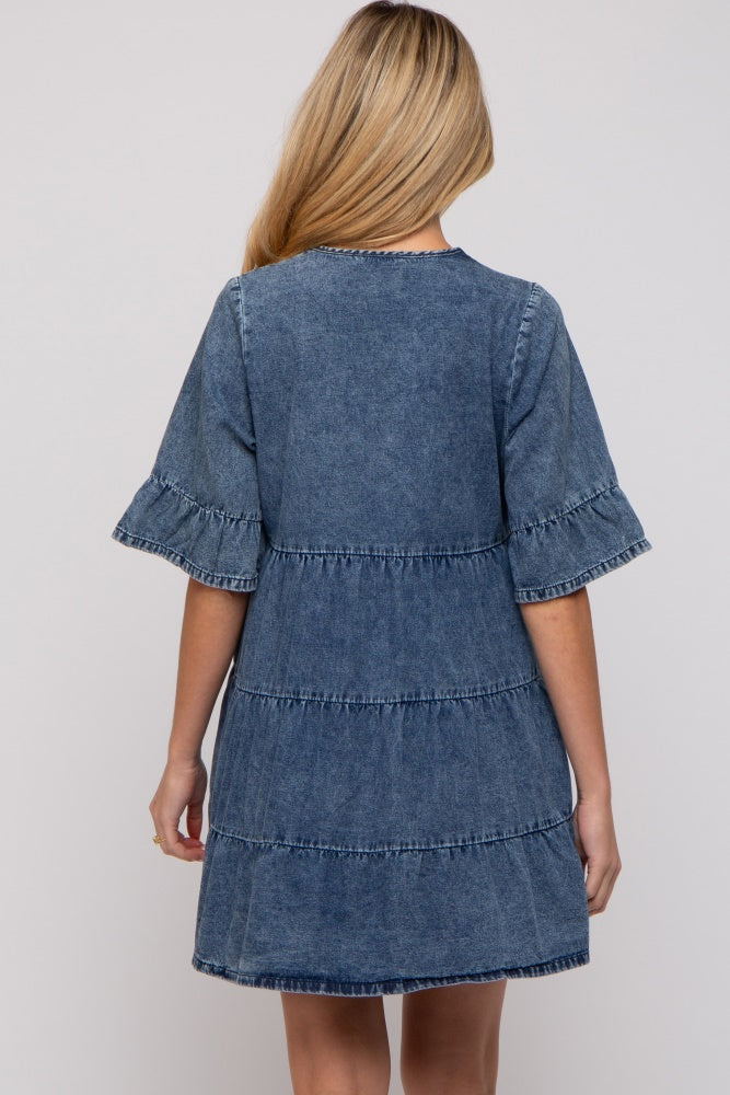 woman wearing a denim tiered maternity dress with short, ruffled sleeves and a relaxed fit, showing her baby bump