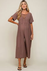pregnant woman wearing a mauve lace-up short sleeve maternity jumpsuit with wide legs