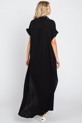 woman wearing a black maxi dress with short sleeves and a relaxed fit, seen from the back