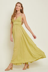 woman wearing a long olive green sleeveless maxi dress with a ruffled bodice and tan block heel sandals