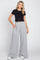 woman wearing a fitted black cropped t-shirt and light grey wide-leg sweatpants with side pockets