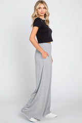 woman wearing a black short sleeve crop top and grey wide-leg pants with pockets