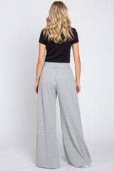 woman wearing a black short sleeve top and light gray wide-leg pants, view from the back