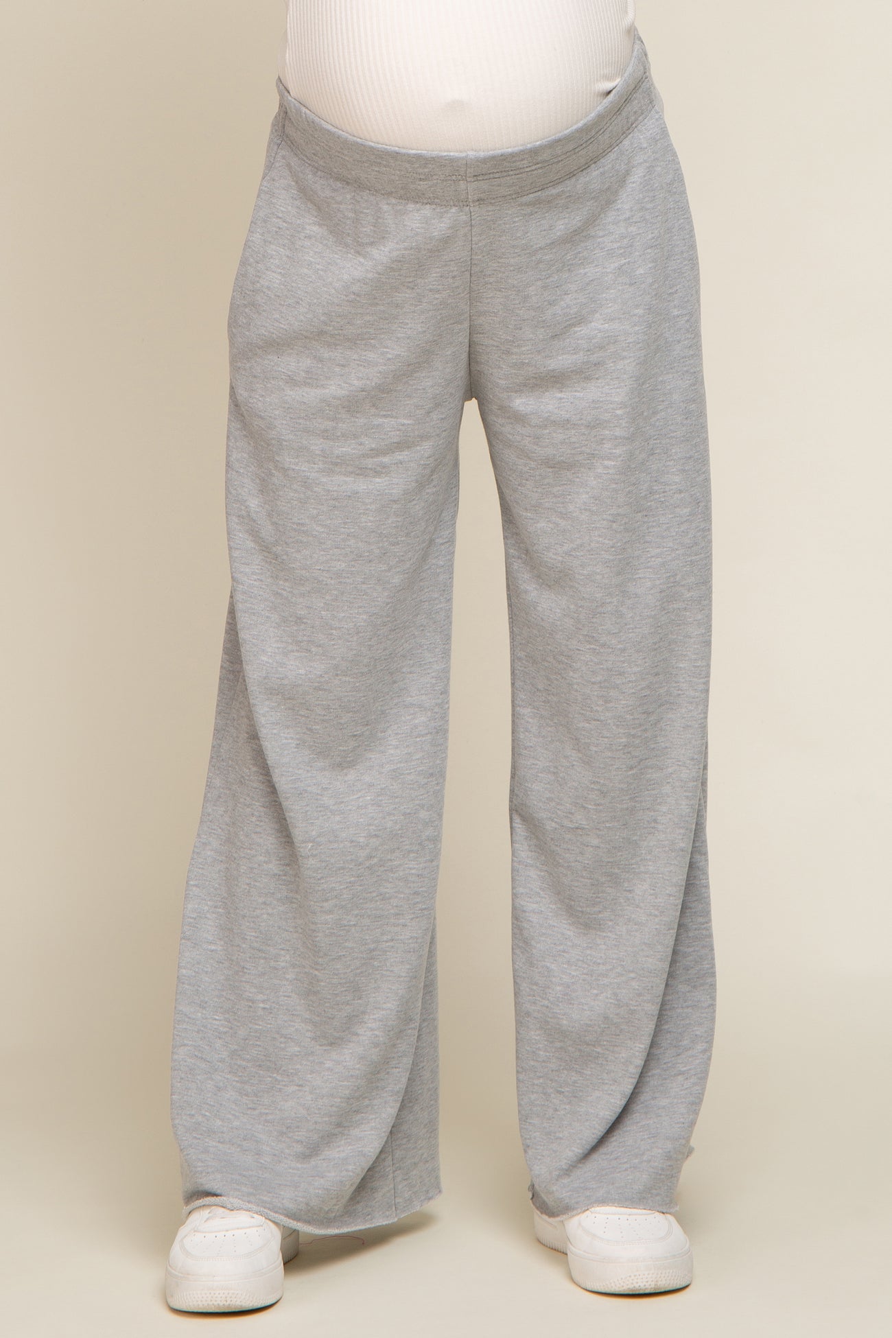 woman wearing gray maternity sweatpants with a comfortable fit and an elastic waistband, visible baby bump
