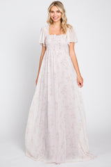 Woman wearing a light pink floral maxi dress with smocked bodice and flutter sleeves